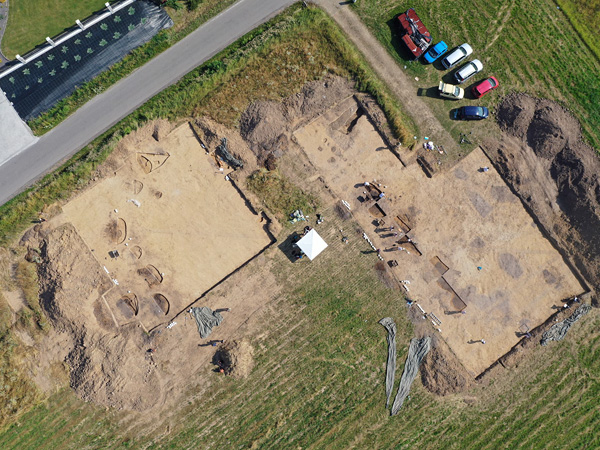The excavation site seen from a bird's eye view: two rectangular fields devoid of topsoil and with numerous pits